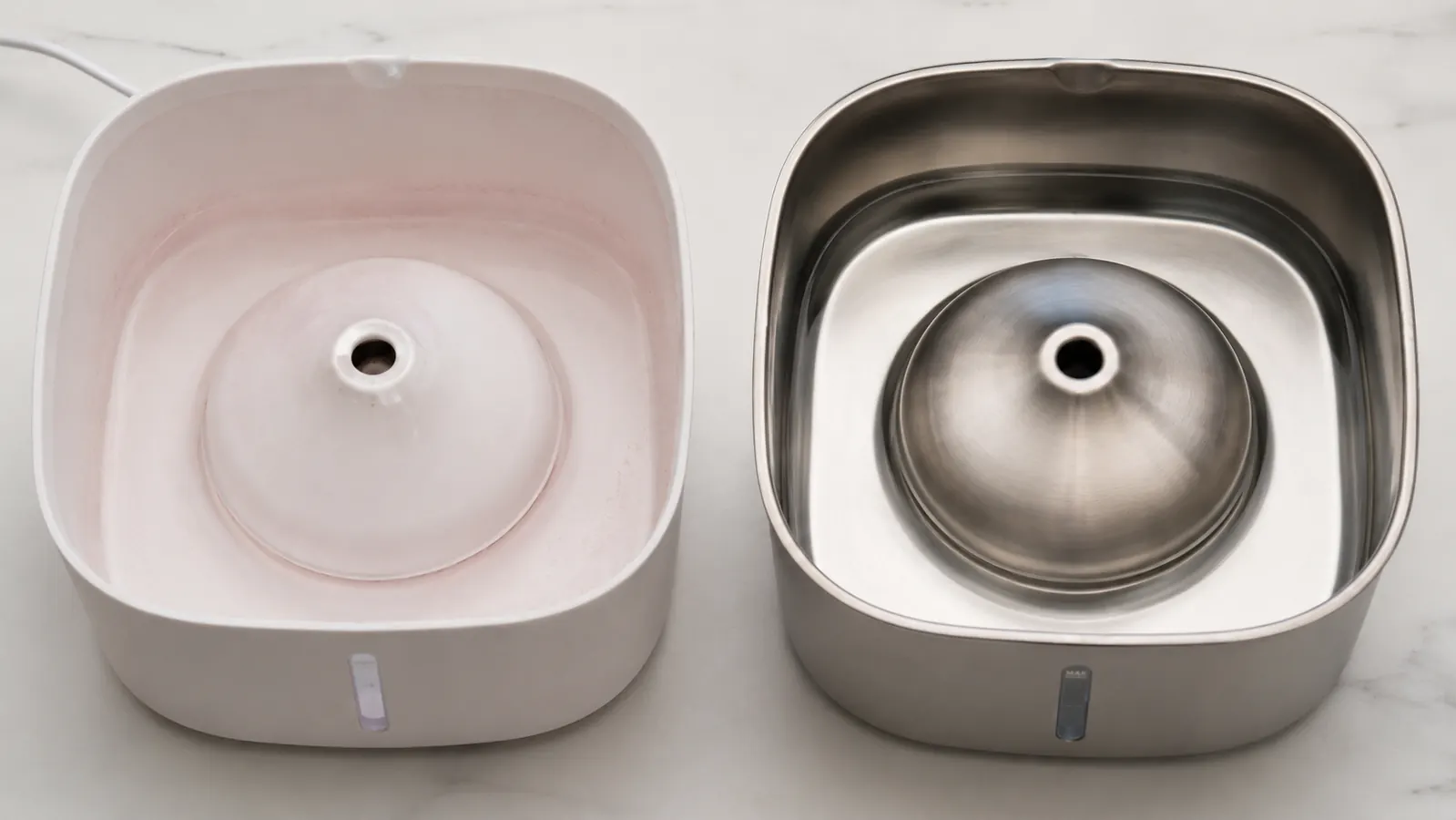 Underside of a plastic cat fountain bowl showing pink biofilm buildup compared to a clean stainless steel bowl